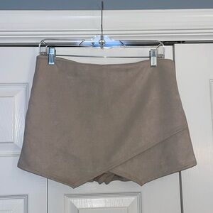 Women’s nude shorts with crossover fabric in the front. Zipper close.